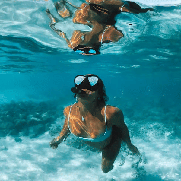 Snorkeler swimming at the surface of clear turquoise water | Tamarind Hills Resort and Villas - Antigua